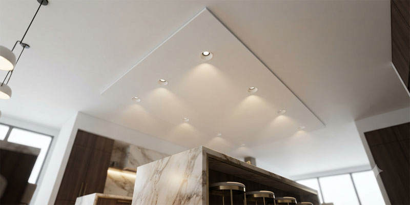 Recessed canless LED ceiling lights providing glare-free task and ambient illumination over a modern marble kitchen island