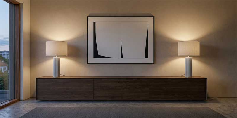 Table lamps for living room set of 2 styled symmetrically on an elongated timber media credenza framing artwork.